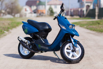 Blue modern scooter on the gravel road © Oleksii Nykonchuk