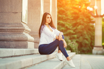 cute girl sitting on the steps, girl summer sitting on the city street, urban style