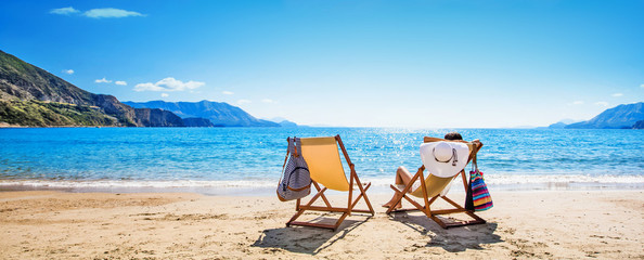 Woman enjoying sunbathing at beach - obrazy, fototapety, plakaty