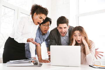 Group of an astonished young multiethnic businesspeople