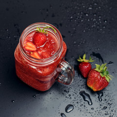 .Strawberry smoothies on a black background with splashes of water. Format for instagram.