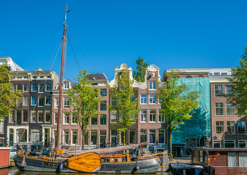 Amsterdam, May 7 2018 - Prinsengracht channel with traditional houses and living boats on a sunny day