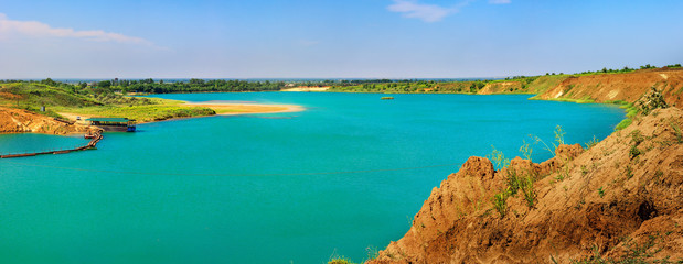 Artificial lake in the sand quarry. Sunny summer day.