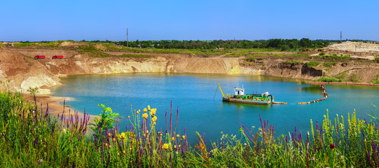 Lake in the sand quarry with the dredge