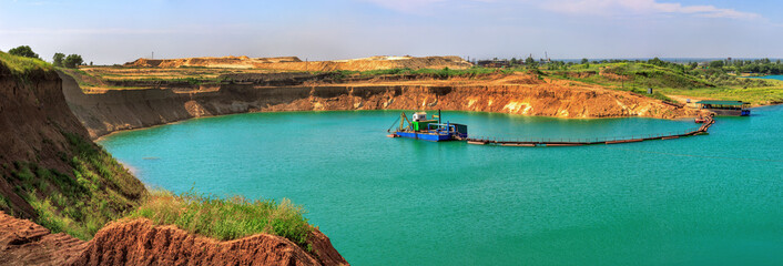 Beautiful lake in the sand quarry with the dredge