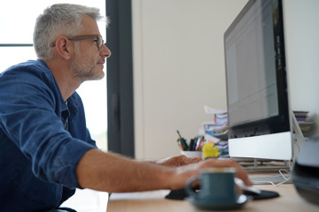 Man at home working on desktop computer