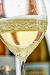 Ein Glas Sekt und Flaschen im Hintergrund