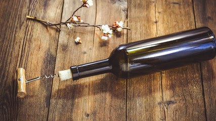 a bottle of wine. corkscrew for cork. wooden background.