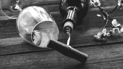 a bottle of wine. corkscrew for cork. wooden background.