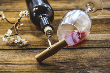 a bottle of wine. corkscrew for cork. wooden background.