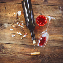 a bottle of wine. corkscrew for cork. wooden background.