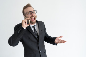 Excited business man talking on smartphone loud and gesturing