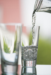 pure,natural freshwater, being poured into a classical trinking glass