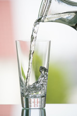 pure,natural freshwater, being poured into a classical trinking glass