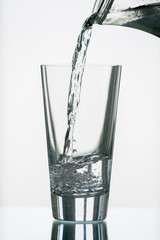 pure,natural freshwater, being poured into a classical trinking glass