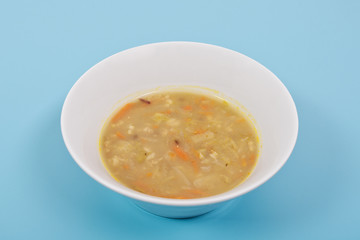 Soup with pasta and vegetables on a blue