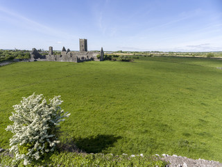 Beautiful aerial birds eye view scenic old ruins of Clare Abbey in County Clare, Ireland. Irish rural countryside with old Irish religious Abbey in decay.