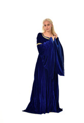 Naklejka premium full length portrait of pretty blonde lady wearing a blue fantasy medieval gown. standing pose on white background.