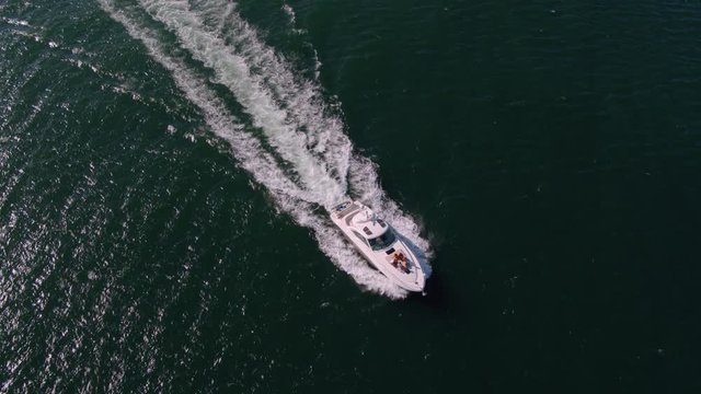 View from drone of young people on a yacht deck. Group of friends on a yacht deck having party.
