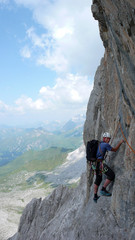 male mountain climber on a steep rock climbing route in the Swiss Alps near Klosters
