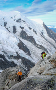 mountain guide and a male client on a rocky ridge heading towards a high summit in the French Alps near Chamonix