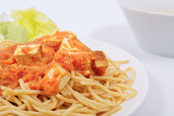 Bolognese spaghetti with tofu on a white