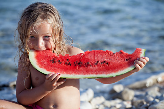 Pretty girl eating big watermelon slice on the beach. Summer, portrait, vacation, relaxation