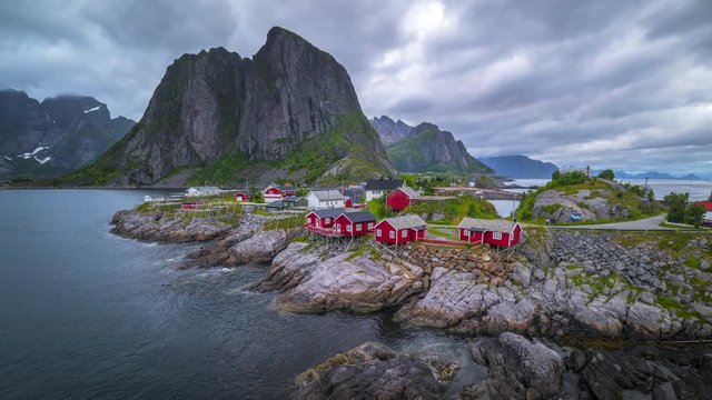 4k timelaspe Moving clouds over traditional Norwegian fisherman's cabins, rorbuer, on the island of Hamnoy, Reine, Lofoten islands, Summer of Norway.