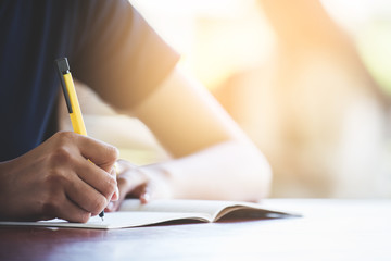A young women writting on the notbook in the morning.