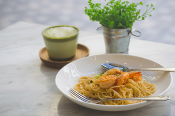spaghetti pasta delicious serve with green tea on the table.