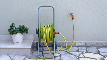 garden hose for irrigation near the house wall