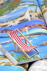 Fototapeta na wymiar Deckchair with travel magazines