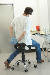 Dentist stretching his legs and arms at work