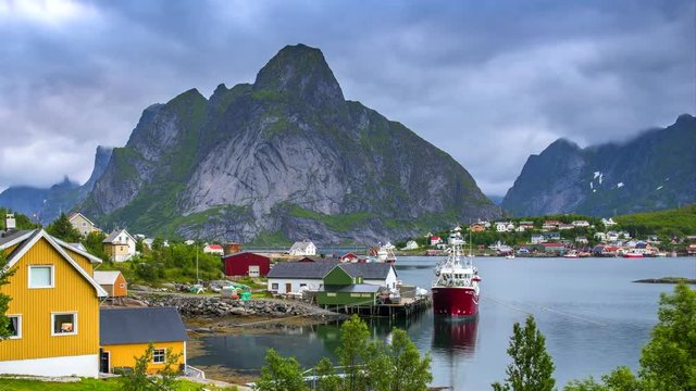 4k timelaspe Moving clouds over traditional Norwegian fisherman's cabins, rorbuer, on the island of Hamnoy, Reine, Lofoten islands, Summer of Norway.