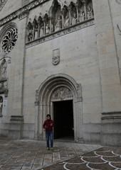 young boy go out of Cathedral of Gemona City in Italy