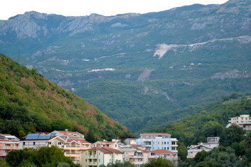 Fototapeta na wymiar Coastal city at the foot of the mountain. Becici, Montenegro, View of the city and mountains