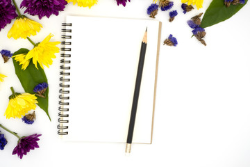 top view book  and pencil for note isolated on white background decorate by chrysanthemum, yellow and purple flower, green leave. Desk office concept with copy space,book and pencil, diary