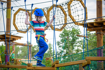 happy boy on the zip line. proud of his courage the child in the high wire park.