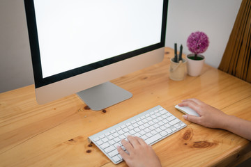 Cropped image of a young woman working on his laptop at home, rear view of business woman hands busy using computer at office desk, young Female student typing on computer sitting at wooden table