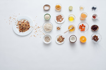 Ingredients for a healthy breakfast - granola, honey, nuts, berries, fruits, top view.