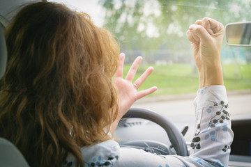 Angry woman screaming while driving a car