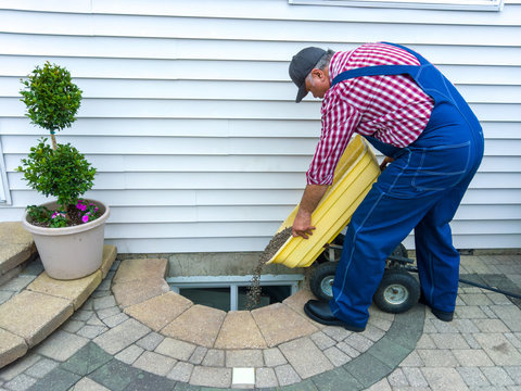 Man doing maintenance on a basement window