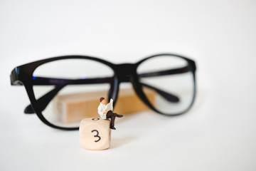 Miniature people, man reading newspaper on wooden block number using as education and business...