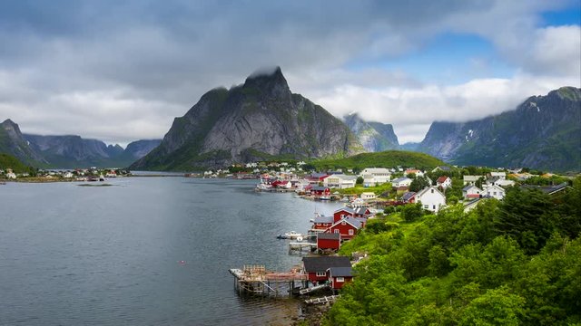 4k timelaspe Moving clouds over traditional Norwegian fisherman's cabins, rorbuer, on the island of Hamnoy, Reine, Lofoten islands, Summer of Norway.