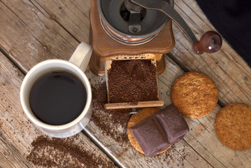 close-up of coffee mug with biscuits and chocolate on wooden boards