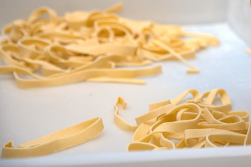 horizontal image of close-up of fresh pasta tagliatelle in container 