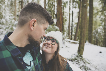 Close-up of loving couple looking each other face to face in forest at Lynn Canyon Park during winter