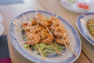 closeup of dish with chinese food grilled shrimps and vegetables