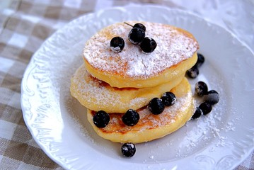 Pancakes with corn flour, sprinkled with powdered sugar and berries