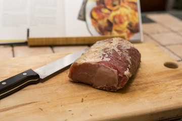 piece of meat being prepared on cutting board with knife 2